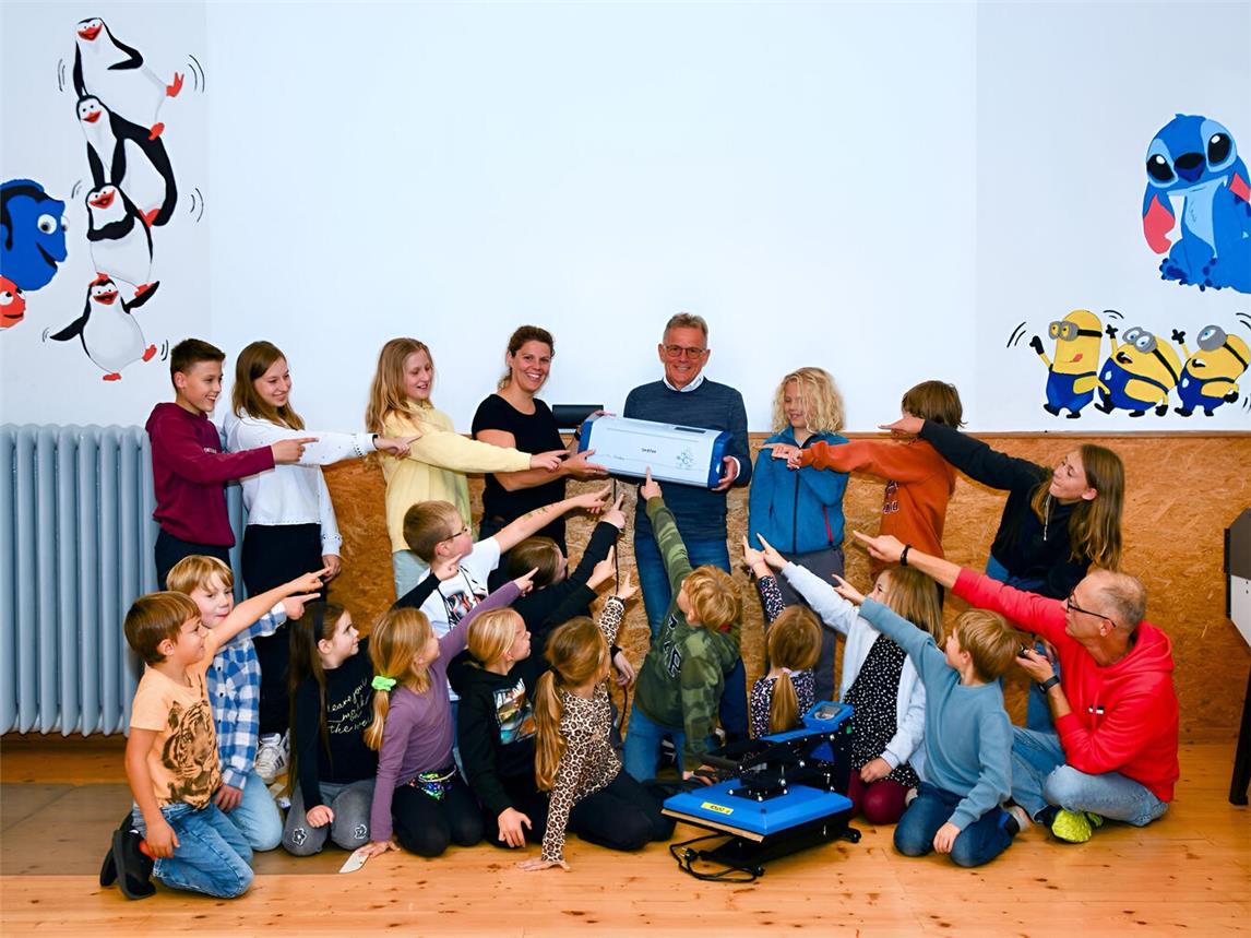 Die Kinder und Jugendlichenfreuen sich auf neue Projekte mit dem Plotter und der Transferpresse. Stefan Opgenorth von der project Unternehmensgruppe (MItte) bei der Übergabe im Jugendfreizeitheim „Päpp“ in Nütterden: Foto: Gemeinde Kranenburg