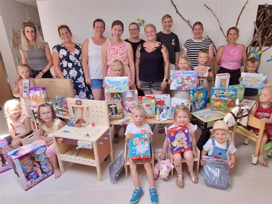 "Gruppe von Eltern und Kita-Team St. Stephanus Hasselt bei Spendenübergabe, lächelnd vor dem Kindergarten."