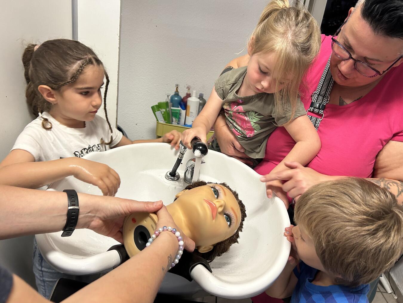 Die Kleinen durften einem Puppenkopf die Haare waschen, ihn föhnen und frisieren. Foto: Lebensquelle