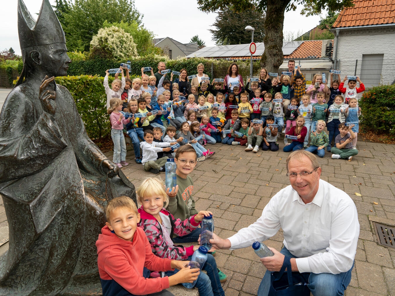 Die neuen Erstklässler der St. Hubertus Grundschule freuen sich mit ihren Lehrkräften Frau Vinmans, Frau Hoffmann, Herr Wißfeld, Frau Kessels und der Rektorin Frau Dückers-Janßen über die neuen Trinkflaschen der Stadtwerke Kevelaer und der NiersEnergie, die Wolfgang Toonen und Hendrik Kruß überreichten. Foto: Gerhard Seybert