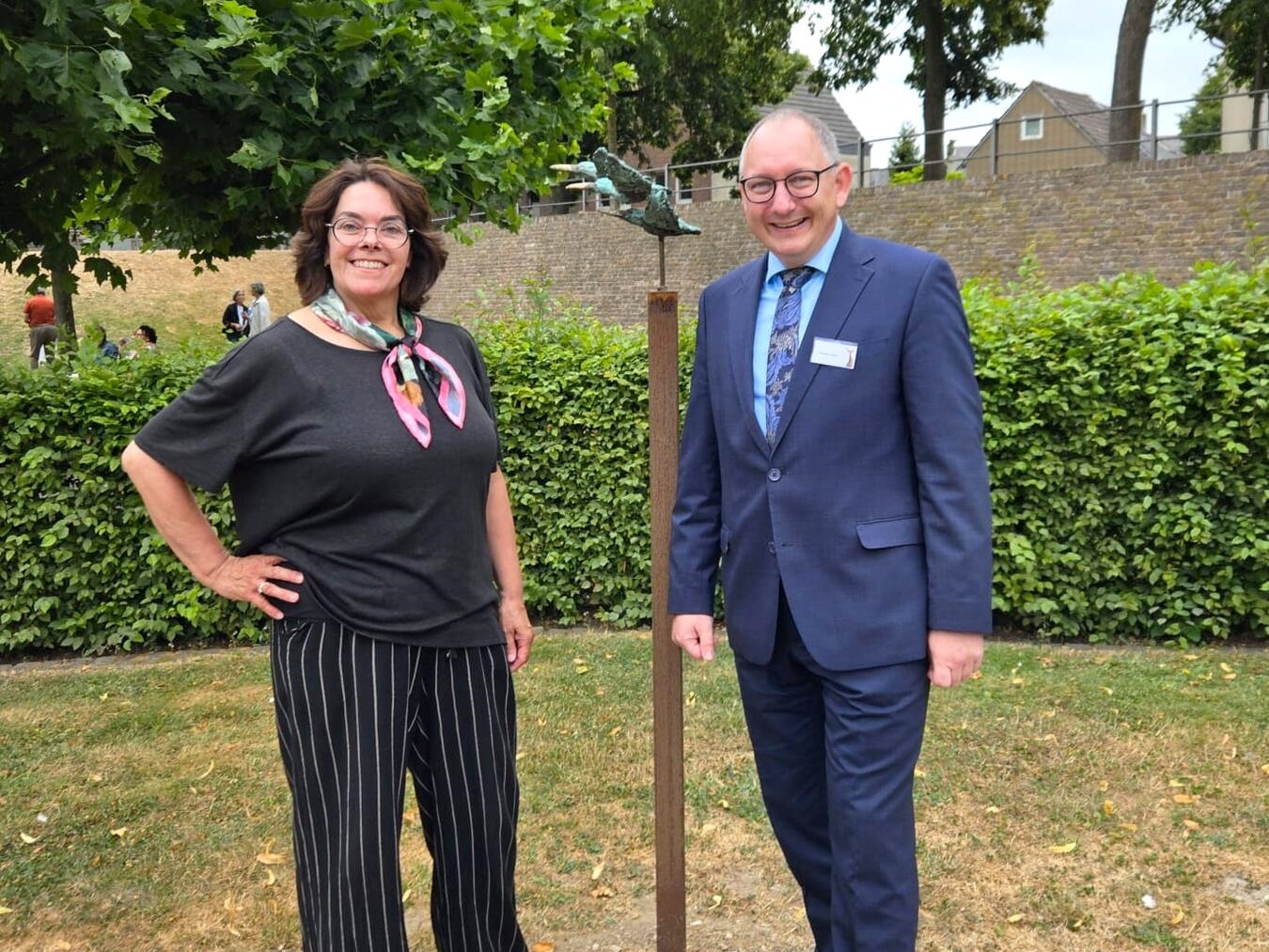 "Künstlerin Maria van der Laar erklärt Bürgermeister Hense ihre Skulptur 'Eisvögel', inspiriert vom Eisvogel in Schaijk, Nordbrabant."