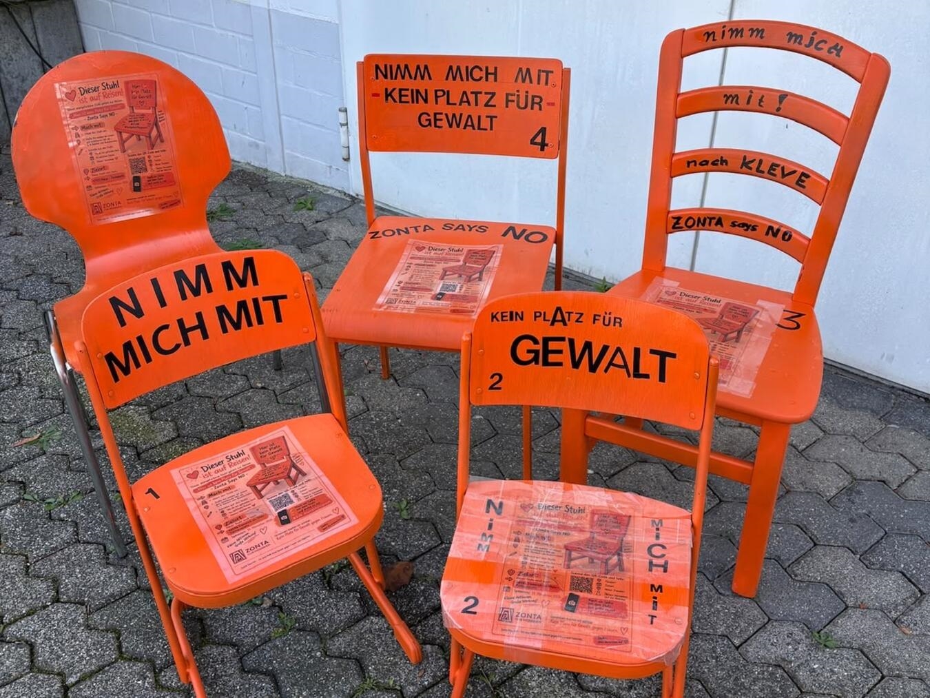 "Orangefarbene Stühle auf Reisen, Zonta Club Niederrhein, symbolisieren Mobilität und Gemeinschaft"