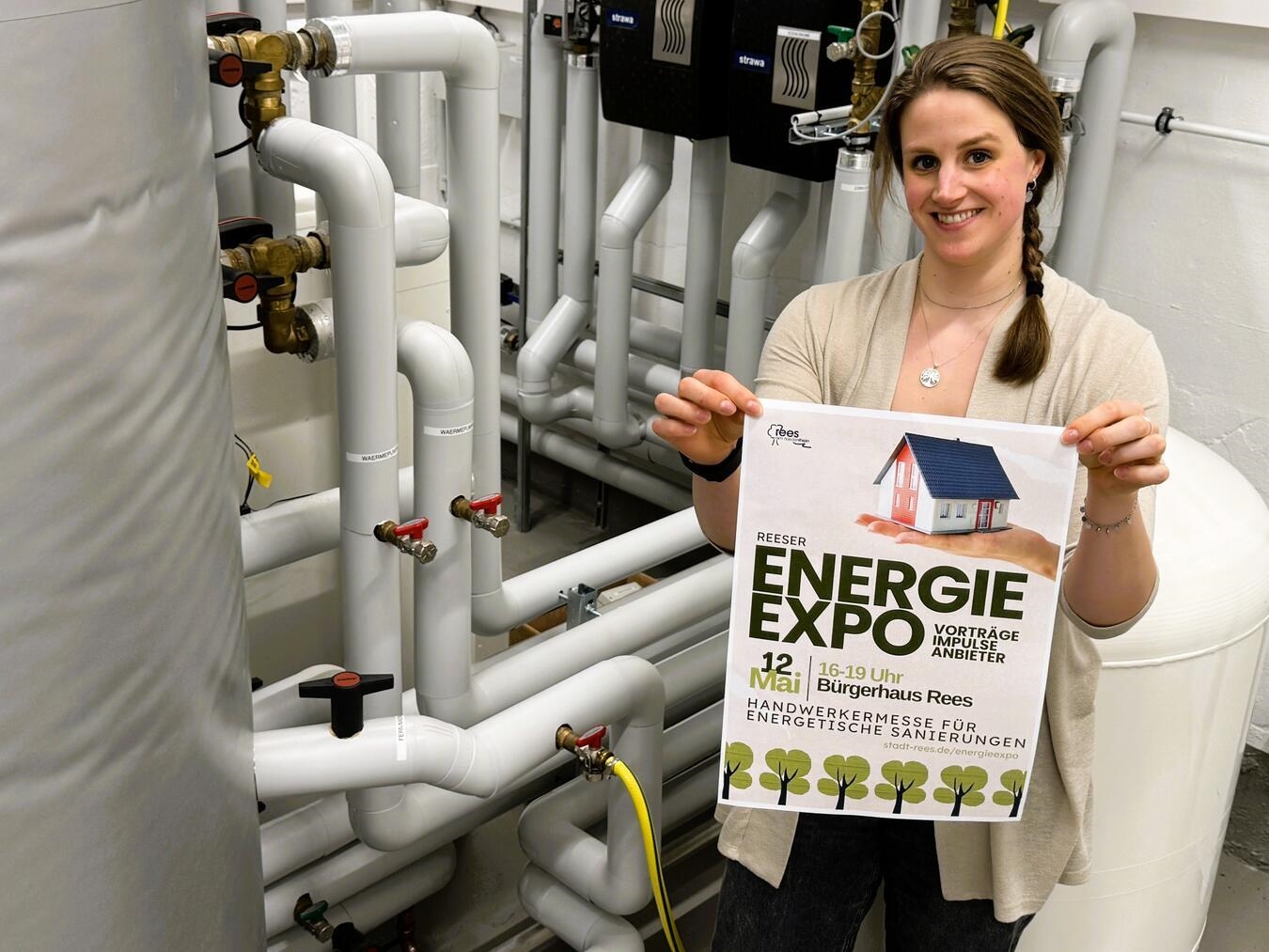 "Christine Klanten wirbt für Reeser Energie Expo, Klimaschutzmanagerin vor Heizungsanlage"