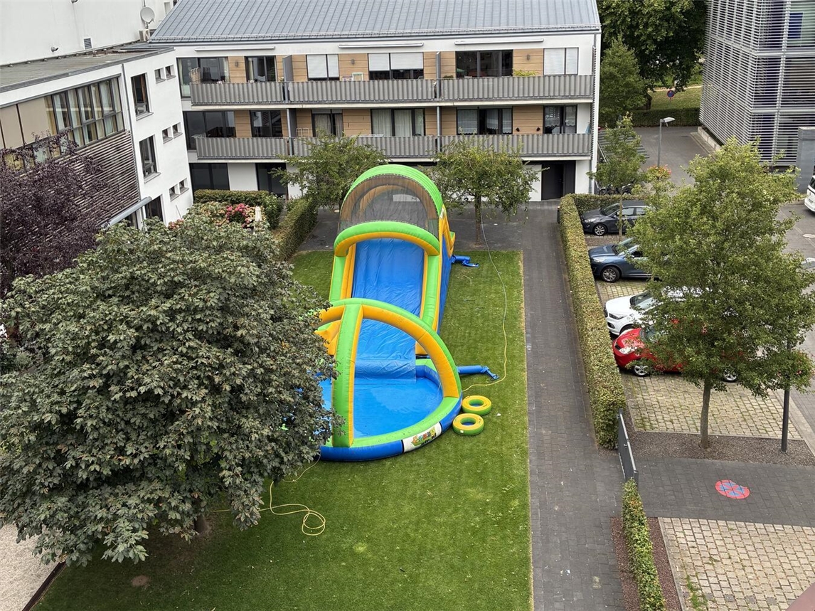 "Riesige Wasserrutsche mit lachenden Kindern im Sommer, Spaß und Abenteuer im Wasserpark"