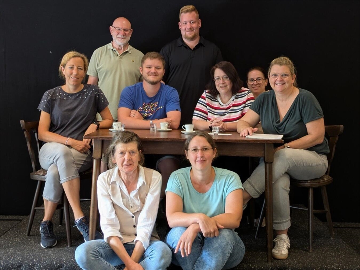 Schauspieler lächeln vor Bühne, bereit für Theateraufführung, Freude und Erwartung in ihren Gesichtern
