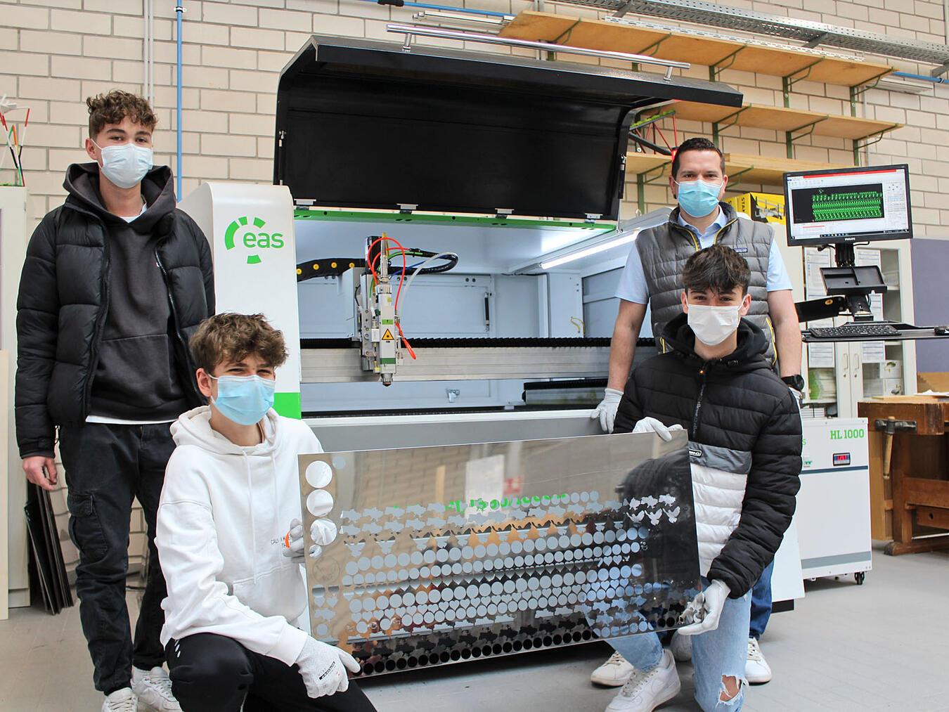 Die Schüler um Lehrer Heiko Keysers (r.) stellen die Anstecker mit dem Lasercutter her.NN- Foto: T. Langer