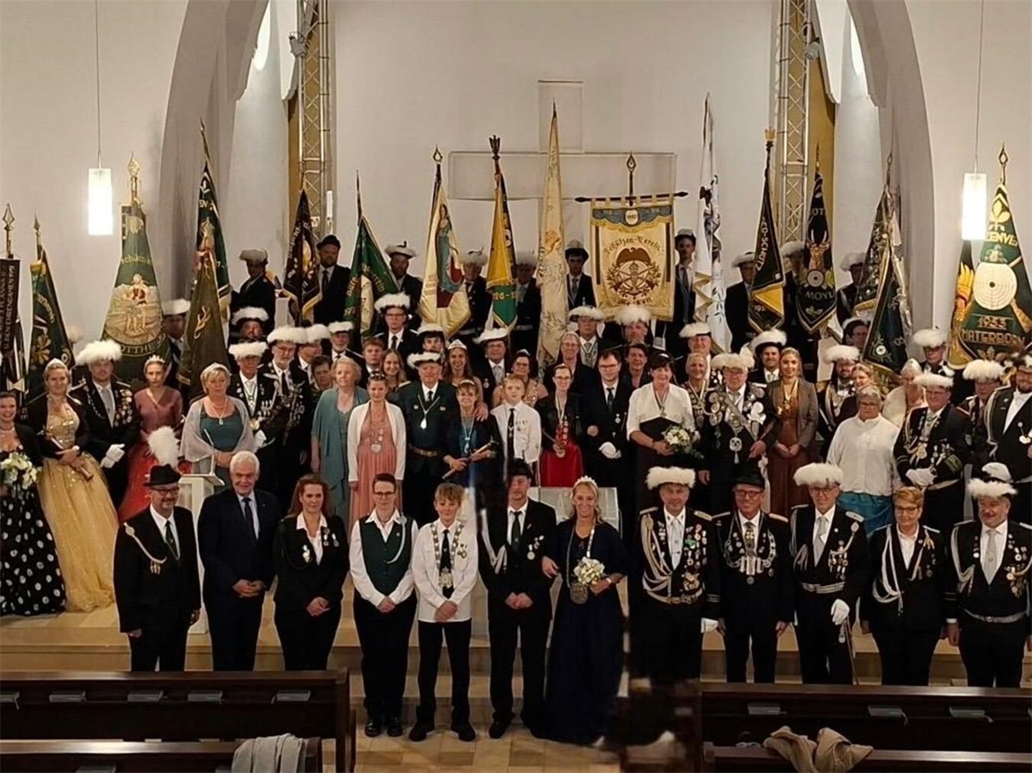 "Schützenfamilie der KKSV feiert Saisonabschluss, Gruppenfoto mit Vereinsfahne"