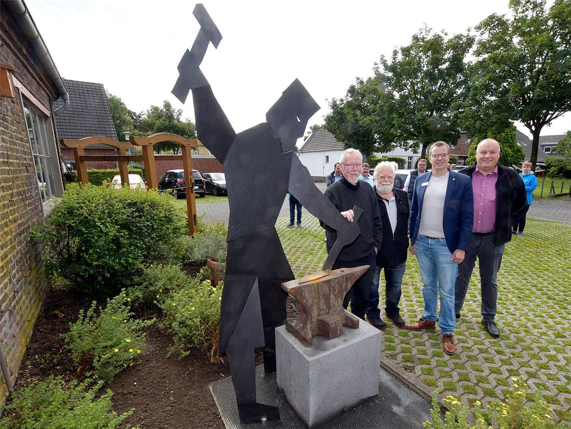 Die Skulptur „Schmied“ ziert jetzt die Dorfmitte. Das freut (v.l.) Künstler Wolfgang Frische, Stifter Willy Goebels, Bürgermeister Stephan Reinders und Hans-Peter Linzen. NN-Foto: Rüdiger Dehnen