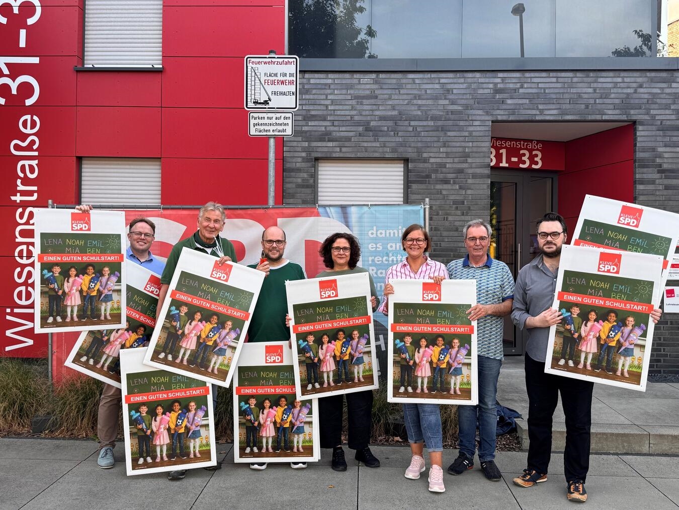 SPD Kleve Vorstand wünscht Erstklässlern mit Plakat alles Gute zum Schulstart. Foto zeigt Vorstandsmitglieder.