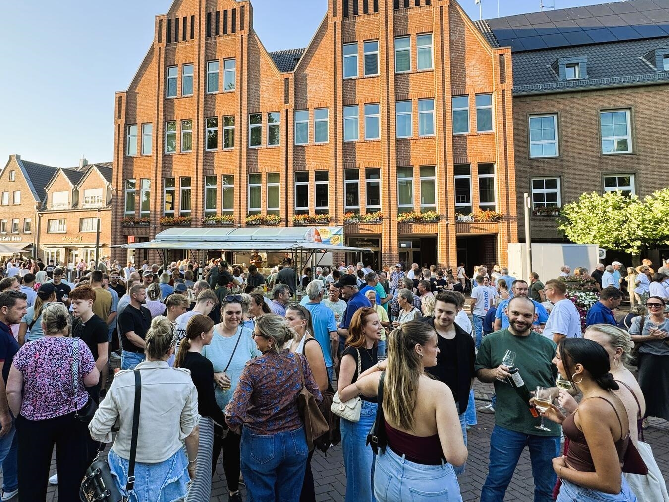 "Feierabendmarkt in Rees, Menschen genießen den letzten Markt des Jahres, Stadtatmosphäre bei Sonnenuntergang"