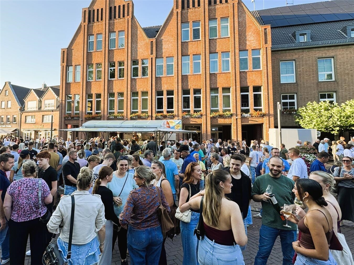 "Feierabendmarkt in Rees, Menschen genießen den letzten Markt des Jahres, Stadtatmosphäre bei Sonnenuntergang"