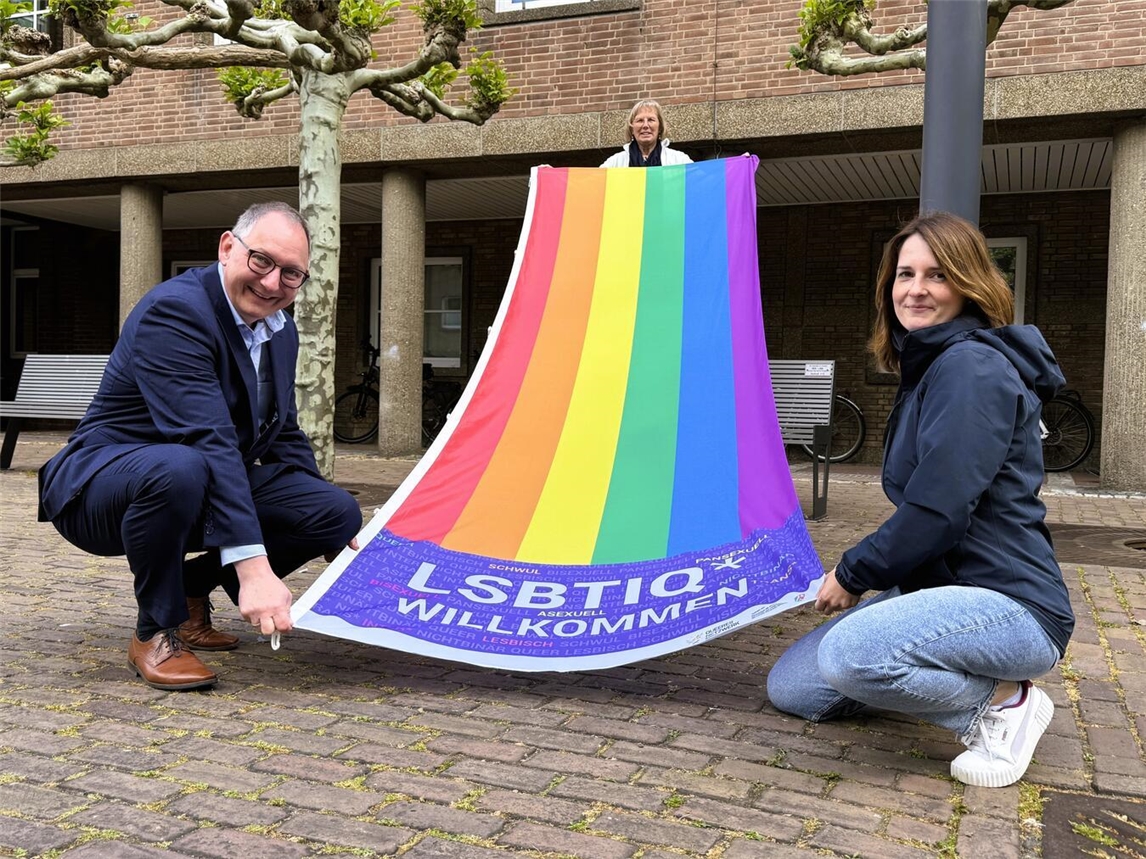 "Rees zeigt Flagge zum IDAHOBIT: Bürgermeister Hense übergibt Staffelstab an Gleichstellungsbeauftragte Katharina Richter, mit Birgit Fischer."