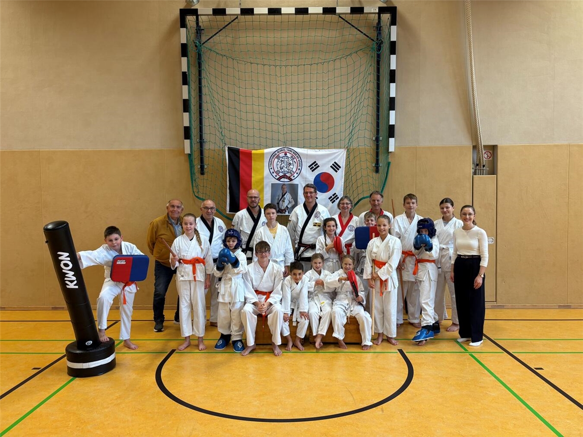 Die Tang Soo Do Abteilung des TV Issum rund um Tang Soo Do-Meister Achim Brall (hinten Mitte) trainiert schon seit Wochen für die Internationale Meisterschaft am 25. Oktober. Hermann Lemmen von der Stiftung Rückenwind (2.v.l.) und Volksbank-Geschäftsstellenleiterin Sophia Stenmans (r.) schauten beim Training vorbei, um den Sportlern viel Erfolg bei der Vorbereitung zu wünschen.Foto: Tang Soo Do Issum