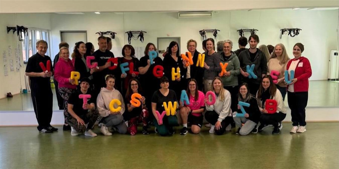 Teilnehmer einer Fortbildung zu Sprache und Bewegung im Sportbereich, Gruppenbild im Freien.