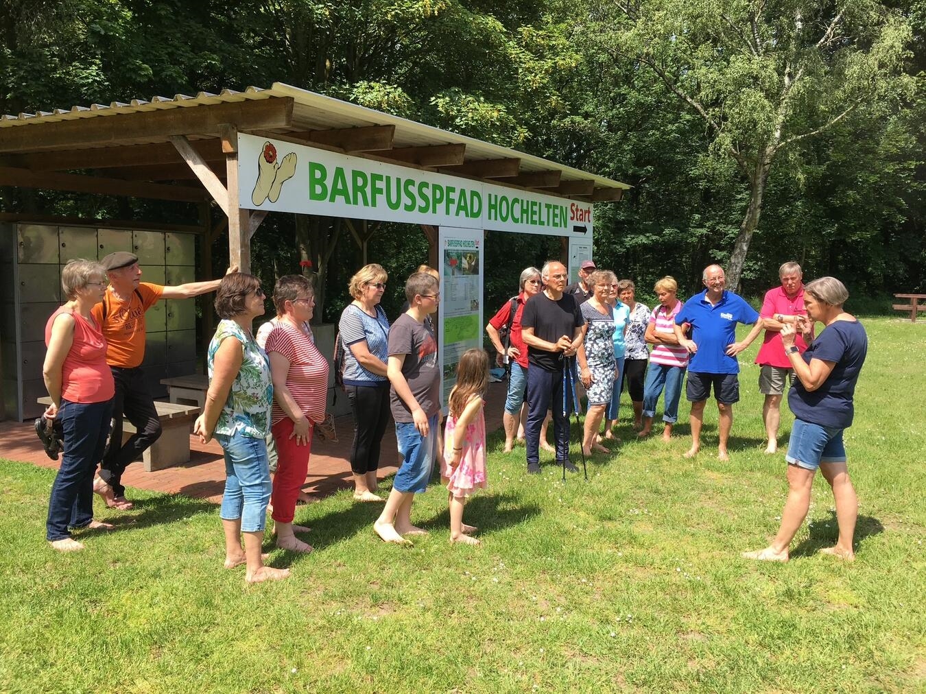 "Teilnehmer starten Wanderung am Barfußpfad Hochelten, Naturerlebnis im Grünen"