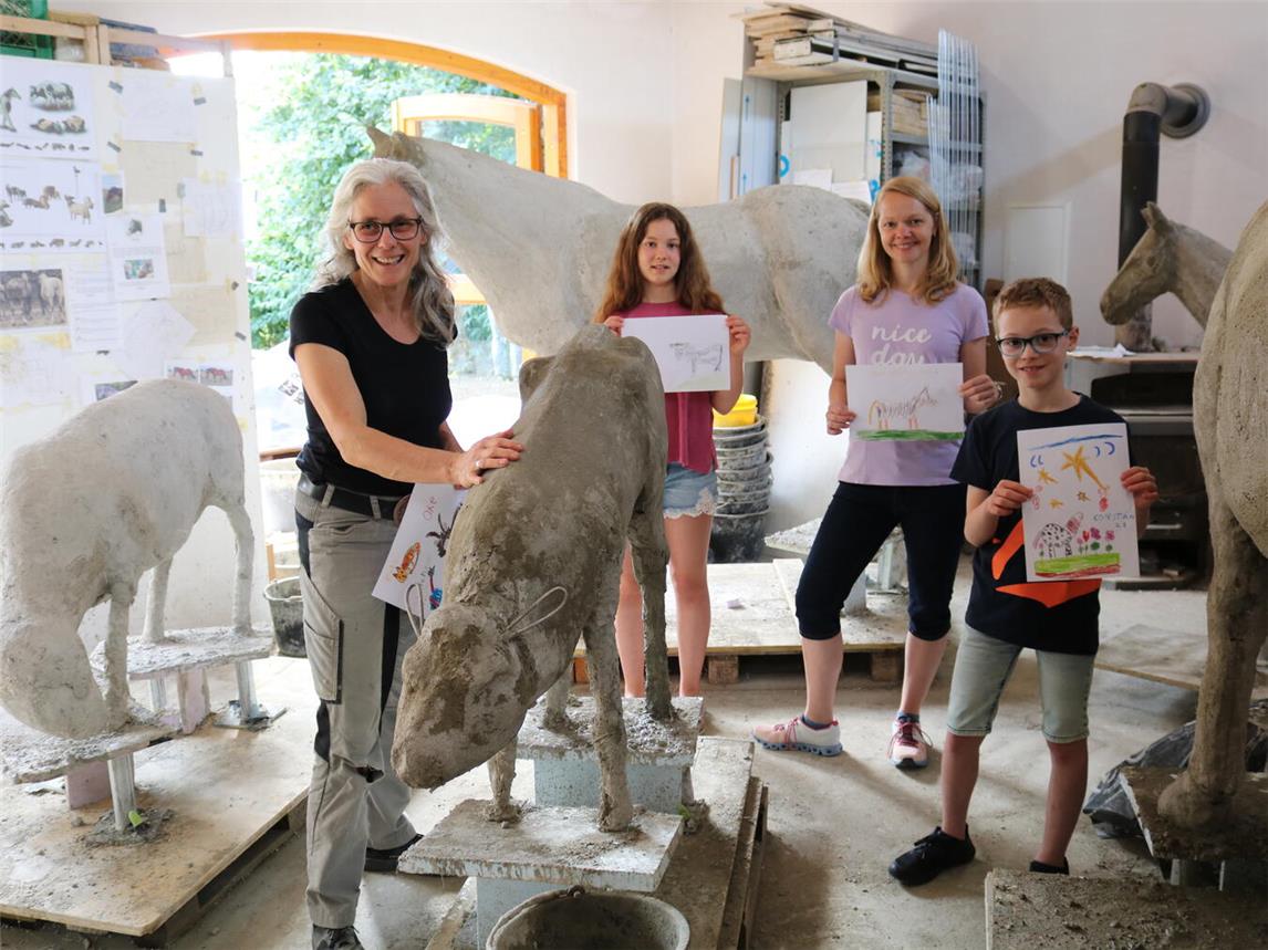 Die Vorfreude auf die fertige „Keppelner Herde“ wächst: Künstlerin Nicole Peters in ihrem Atelier mit Henrike, Marisa und Roman Urselmans (v. l.), die beim Beton aufbringen helfen durften. NN-Foto: CDS