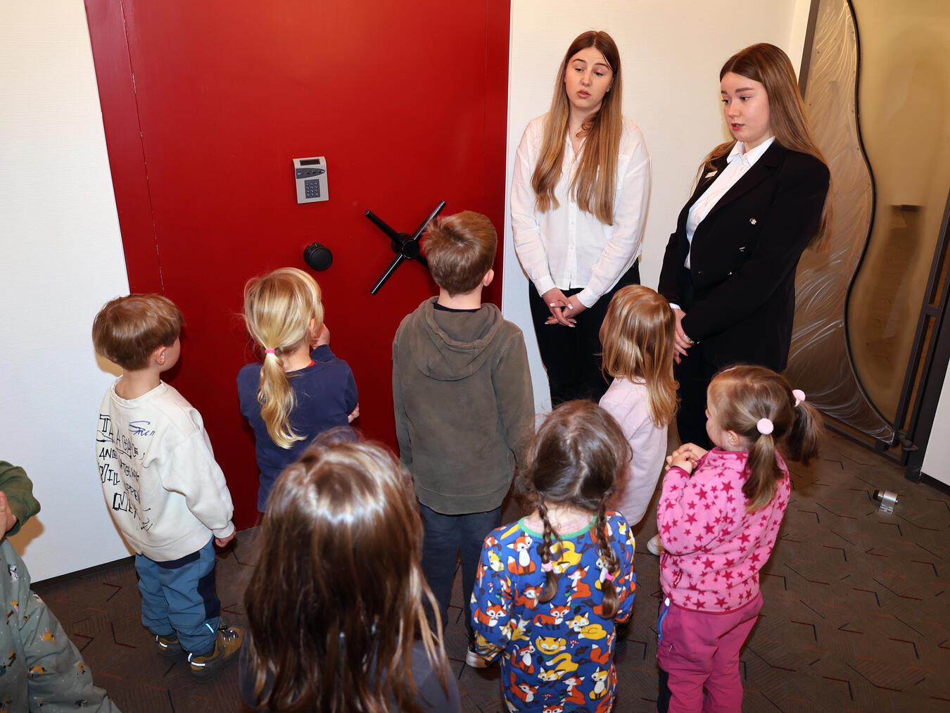 Die Vorschulkinder des Alpener Waldkindergartens besuchten die Sparkasse an der Burgstraße. Die Beraterinnen Svenja Stülpner (l.) und Eileen Rottstegge organisierten für die kleinen Besucher eine spannende Schatzsuche. Die endete mit großem Hallo und schönen Geschenken im Tresorraum. Foto: Sparkasse