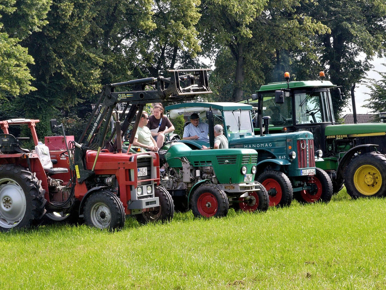 "Vintage-Autos auf Wiese vor Kirche, Besucher bestaunen Oldtimer-Sammlung"