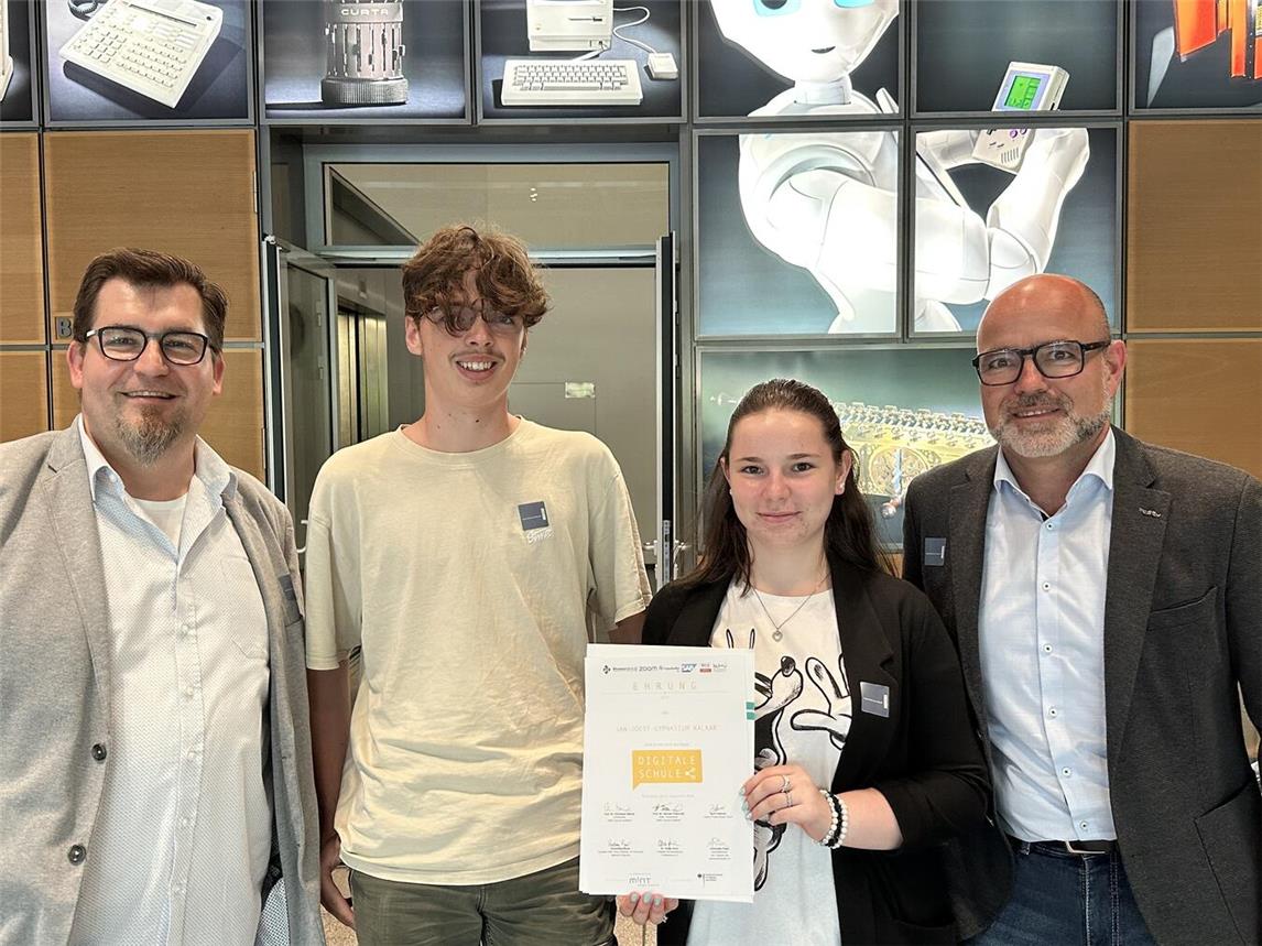 Digitalisierungsbeauftragter Thorsten Wolk, Donovan Nellesen (9b), Kim Krone (EF) der stellvertretende Schulleiter Frank Krebbing (v.l.) freuen sich über die Urkunde. Foto: JJG