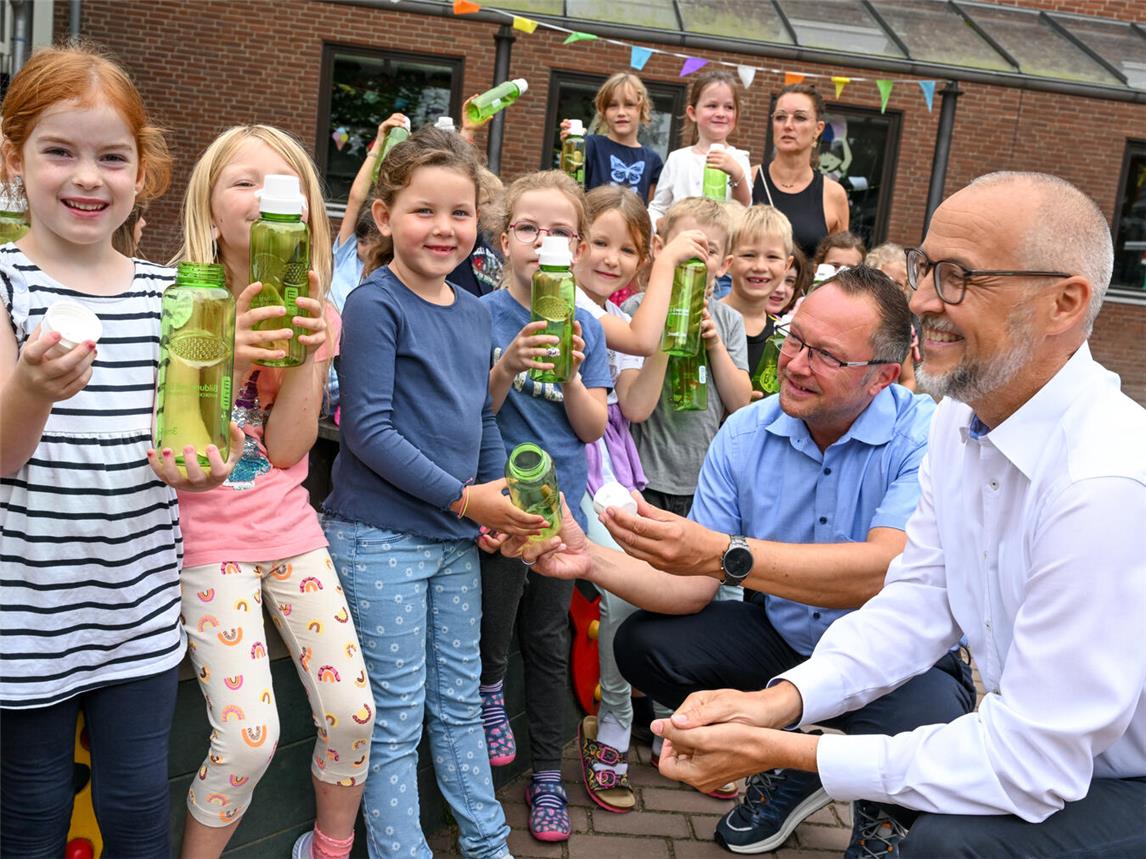 Dirk Krämer (l.), Westenergie-Kommunalmanager, Schulleiterin Daniela Hommen (Mitte.) und Bürgermeister Thomas Görtz (r.) bei der Übergabe der Trinkflaschen an die über 80 Erstklässler. Foto: Westenergie AG