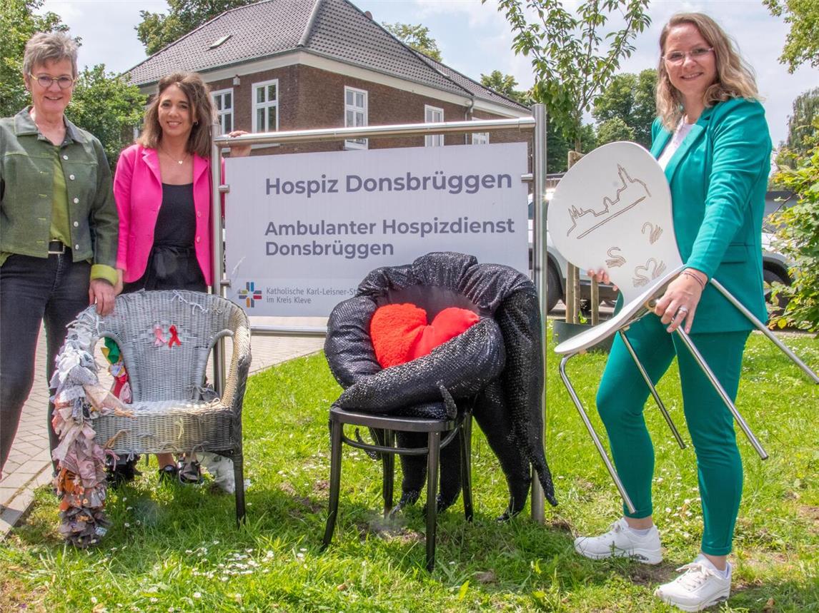 Dorothee Beutler, Jennifer Welles und Marion Aryus (v.l.) mit einigen der kunstvoll gestalteten Stühle, die beim Fest an der Wasserburg Rindern versteigert werden. Foto: Bischöfliche Pressestelle / Christian Breuer