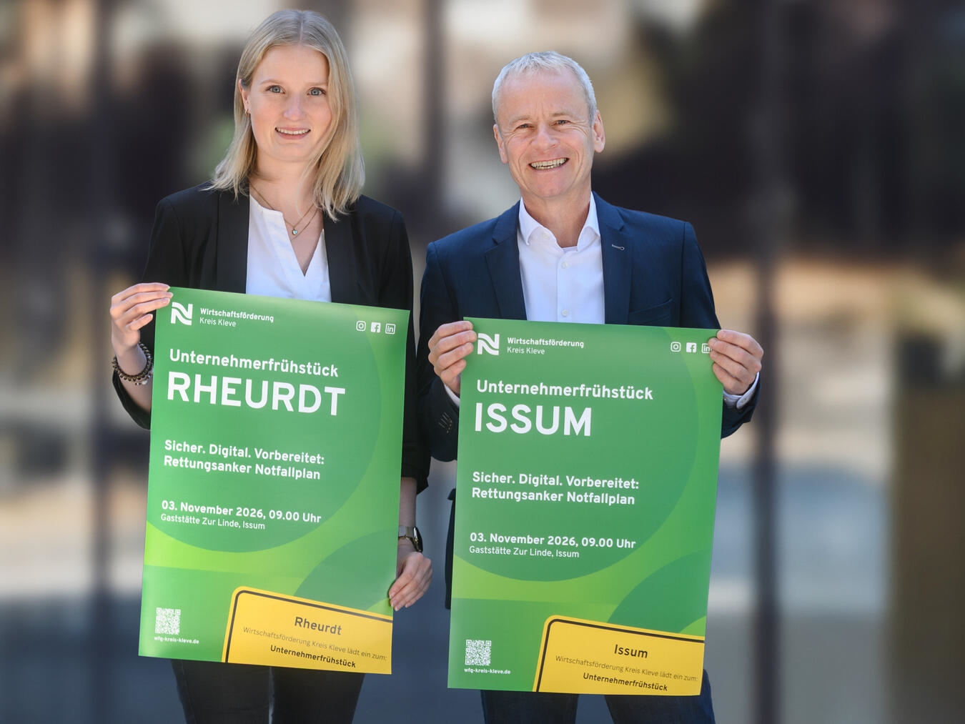 "Dr. Benedikt Rösen und Corinna Strunk präsentieren Plakat für Unternehmerfrühstück in Issum und Rheurdt"