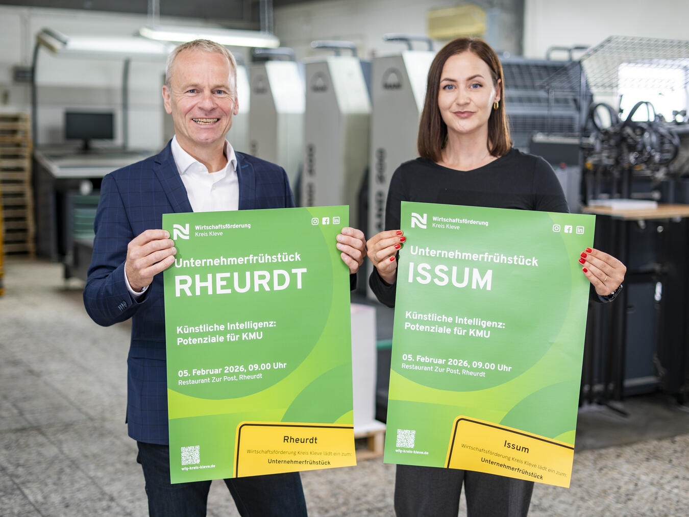 Dr. Benedikt Rösen und Fee Knupp von der Wirtschaftsförderung Kreis Kleve präsentieren das Plakat mit der Einladung zum Unternehmerfrühstück für die Gemeinden Issum und Rheurdt. Foto: WfG Kreis Kleve