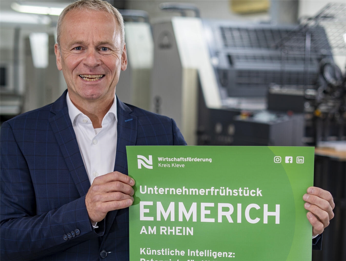 Dr. Benedikt Rösen von der Wirtschaftsförderung Kreis Kleve präsentiert das Plakat mit der Einladung zum Unternehmerfrühstück in Emmerich. Foto: Gerhard Seybert