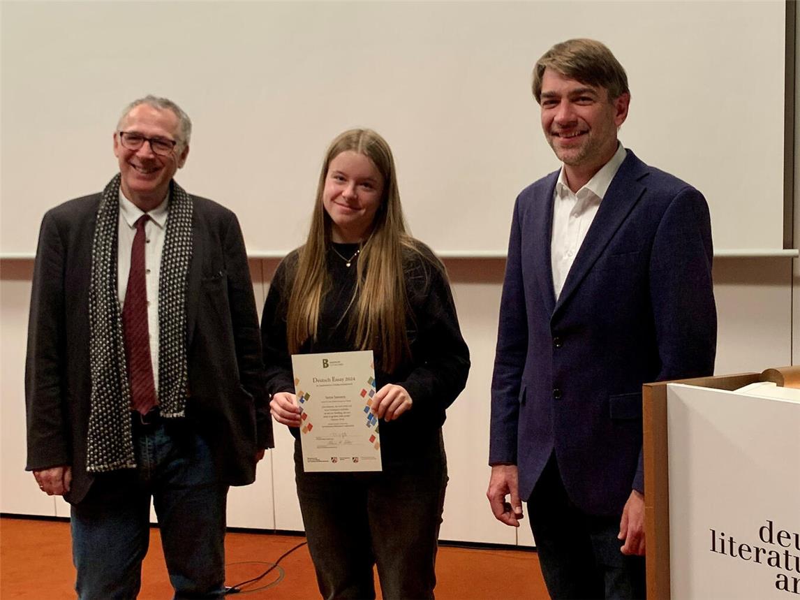 Dr. Bernhard Fischer (Berkenkamp-Stiftung, l.) und David Gels (Bezirksregierung Münster) gratulieren Sanja Janssen.Foto: privat