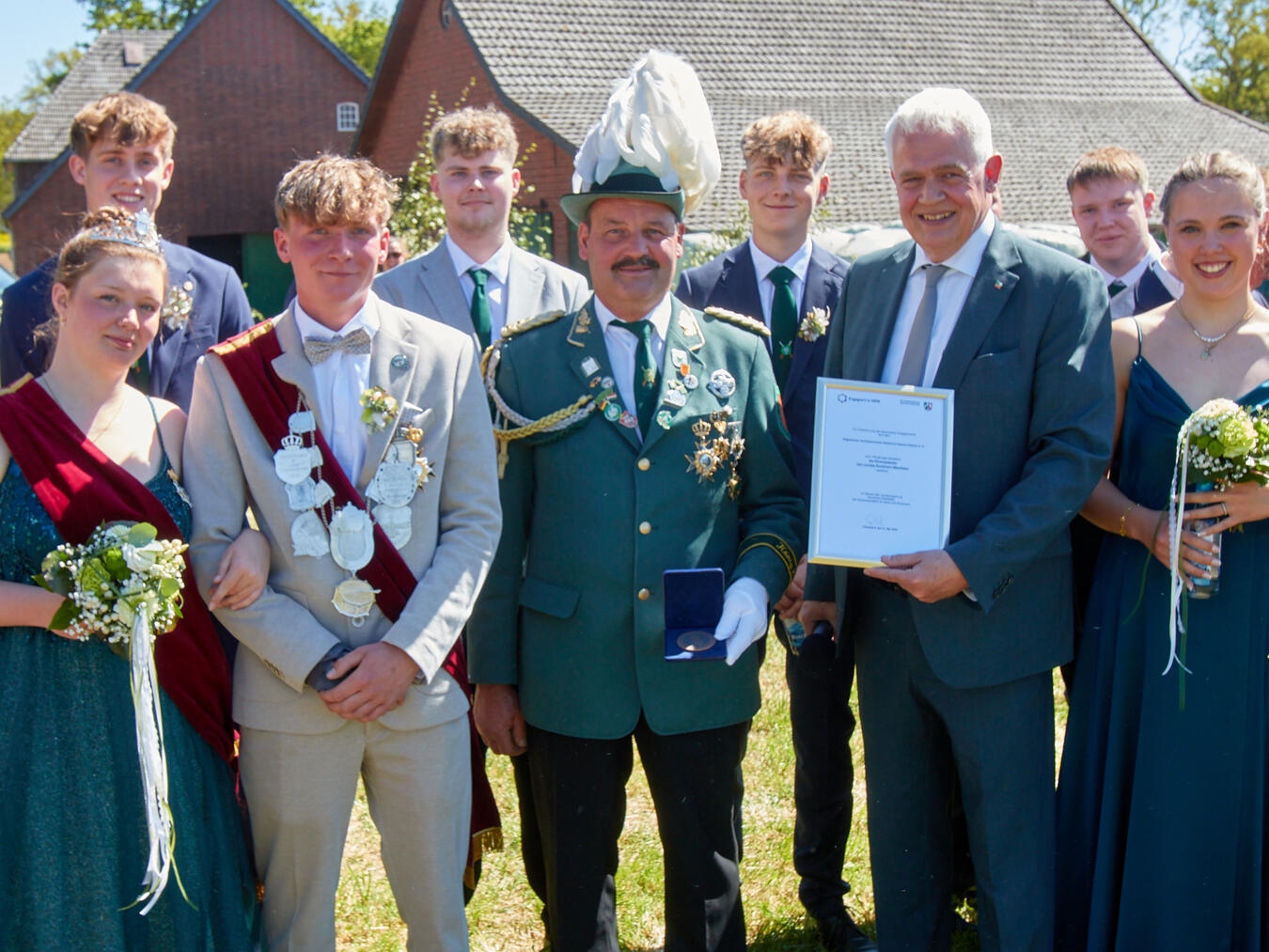 Dr. Günther Bergmann und Gerhard Venhuis überreichen Urkunde; mit Königspaar Jakob Kamps und Alina Teuber, Schützenverein.