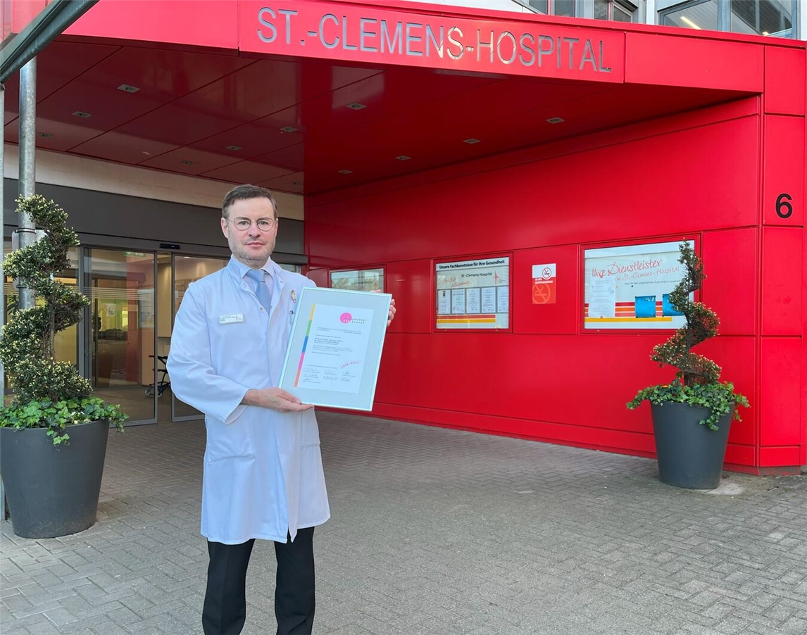 Dr. med. Karsten Thiel mit der Urkunde zur erneuten Auszeichnung „Ausgezeichnet für Kinder 2026-2027“ vor dem St.-Clemens-Hospital Geldern.

