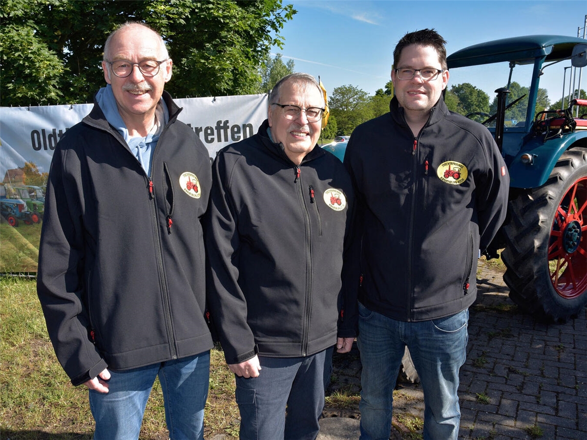 "Drei Mitglieder der Treckerfreunde Kranenburg vor historischem Traktor"