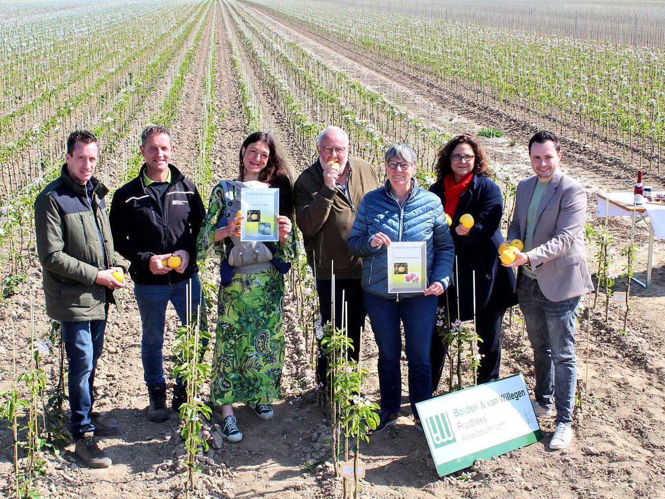 Ein beeindruckender Anblick: Bernd Hesseling (4.v.l.) lud seine Gäste zu einer Besichtigung der neu gepflanzten Apfelbäume ein und überraschte Dr. Barbara Hendricks (3.v.r.) und Paula Backhaus (3.v.l.) mit einer eigenen Sorte. NN-Foto: Thomas Langer
