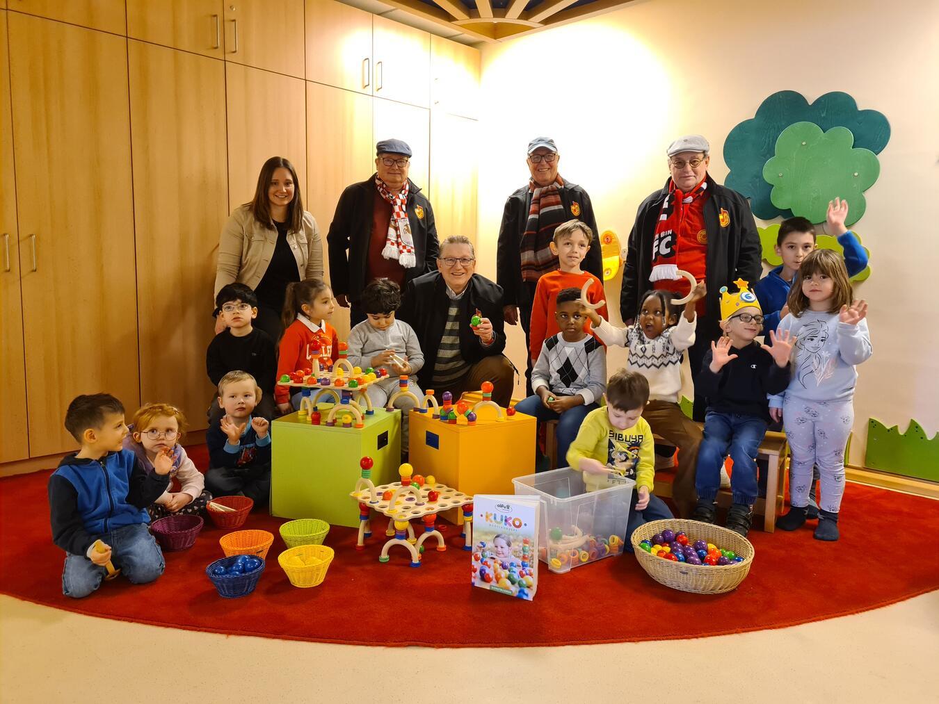 Ein herzliches Dankeschön der Michaelkinder für das neue Spielmaterial: Bernadette Baldeau (Leiterin der Kindertagesstätte) sowie Jakob Willems, Gerd Lange, Jochen Lichte und Hans Kubon von „De kölsche Tön“ im Kreis der Kinder.Foto: Caritasverband Geldern-Kevelaer