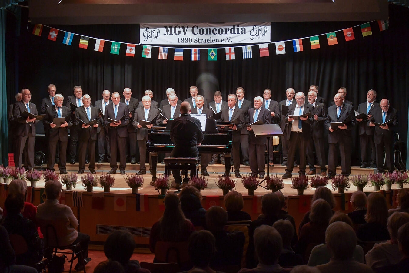 "Weihnachtskonzert in Straelen, festlich geschmückte Bühne, Musiker in Aktion, festliche Atmosphäre"