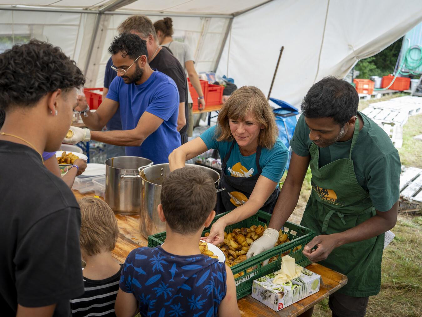 Ein Team nach dem anderen darf sich sein frisches Mittagessen im Esszelt des Abenteuercamps abholen. Fotos (2): Gerhard Seybert