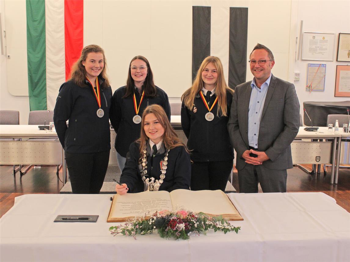 Eine besondere Ehrung für großartige Leistungen: Die Medaillenträgerinnen (stehend, v. l.) Hannah Wehren, Franziska Driessen und Anna Kropmann sowie als neue Bundesjugendprinzessin Annika Kropmann (sitzend) trugen sich auf Einladung von Bürgermeister Thomas Görtz (r.) ins Goldene Buch der Stadt ein. NN-Foto: Thomas Langer