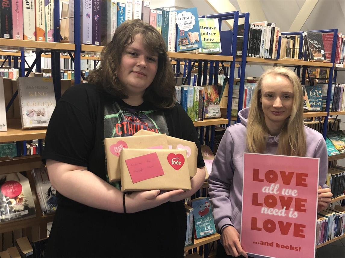 Eine Buchüberraschung zum Ausleihen bieten Liz Collins und Elisabeth Habers (v. li.) von der Reeser Stadtbücherei. Foto: Stadt Rees