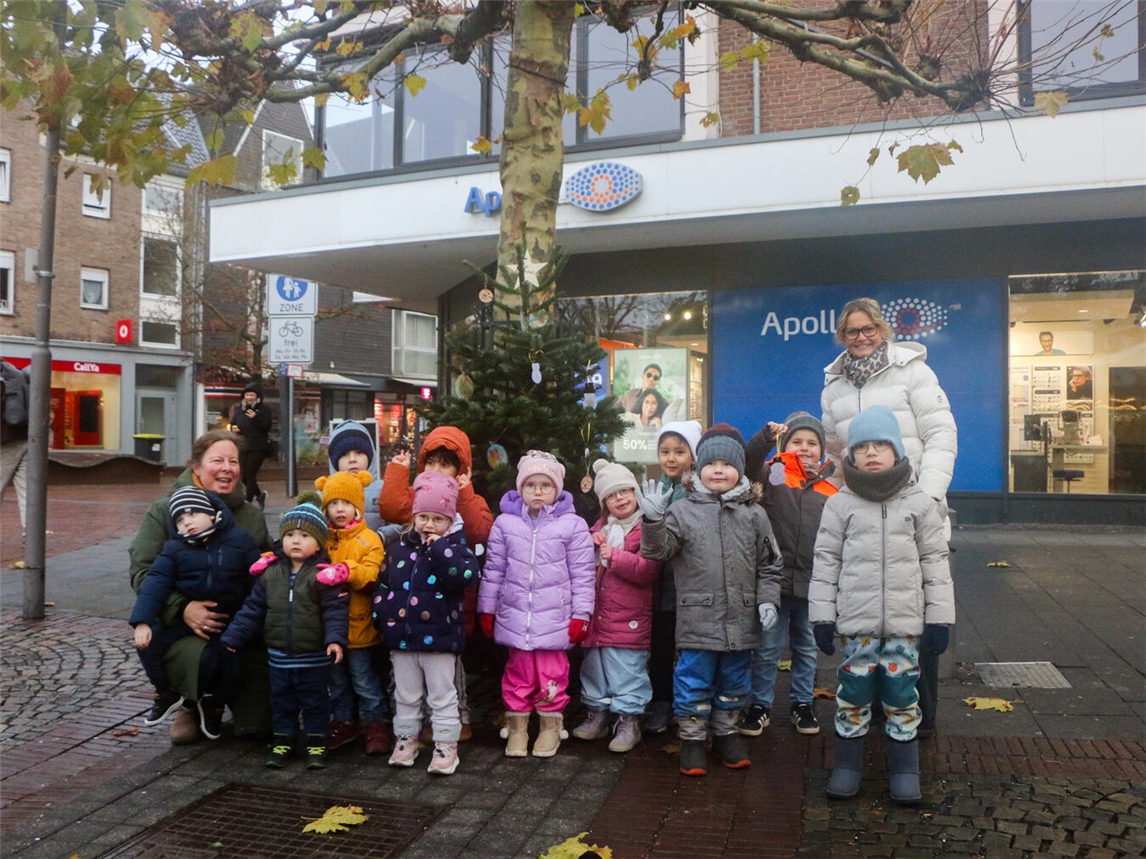 Eine der Kitas, die sich an der Tannenbaum-Schmückaktion beteiligte, war die Gelderner Kita St. Michael – sie schmückte den Tannenbaum vor Apollo am Drachenbrunnen. Mit im Bild: Organisatorin Carmen Eichler (hinten rechts) vom städtischen Tourismus- und Kulturbüro.Foto: Caritas/Deckers