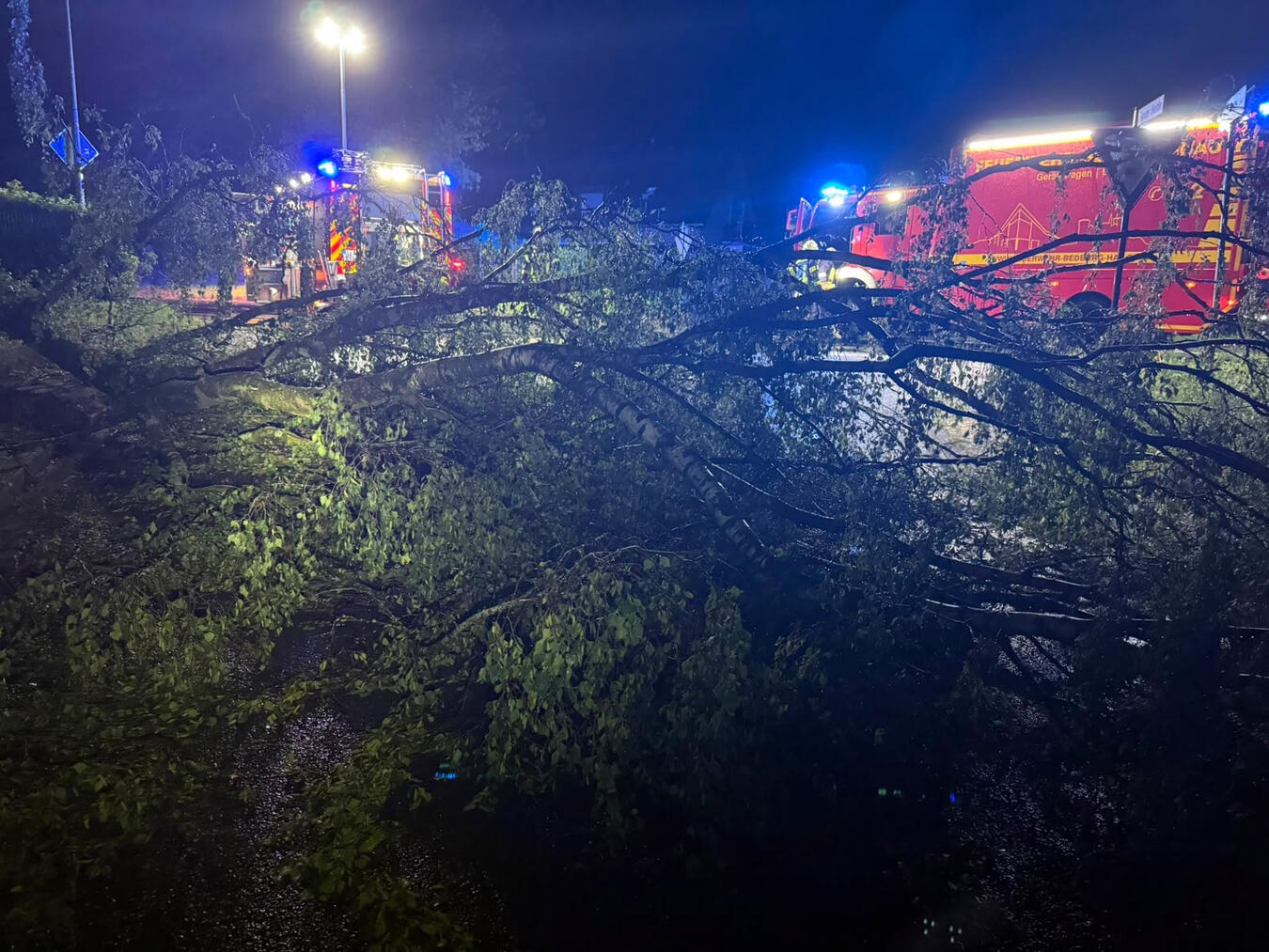 "Nachtszene: Gewitterfront über Bedburg-Hau, Feuerwehr im Einsatz, Blitze und dunkler Himmel"