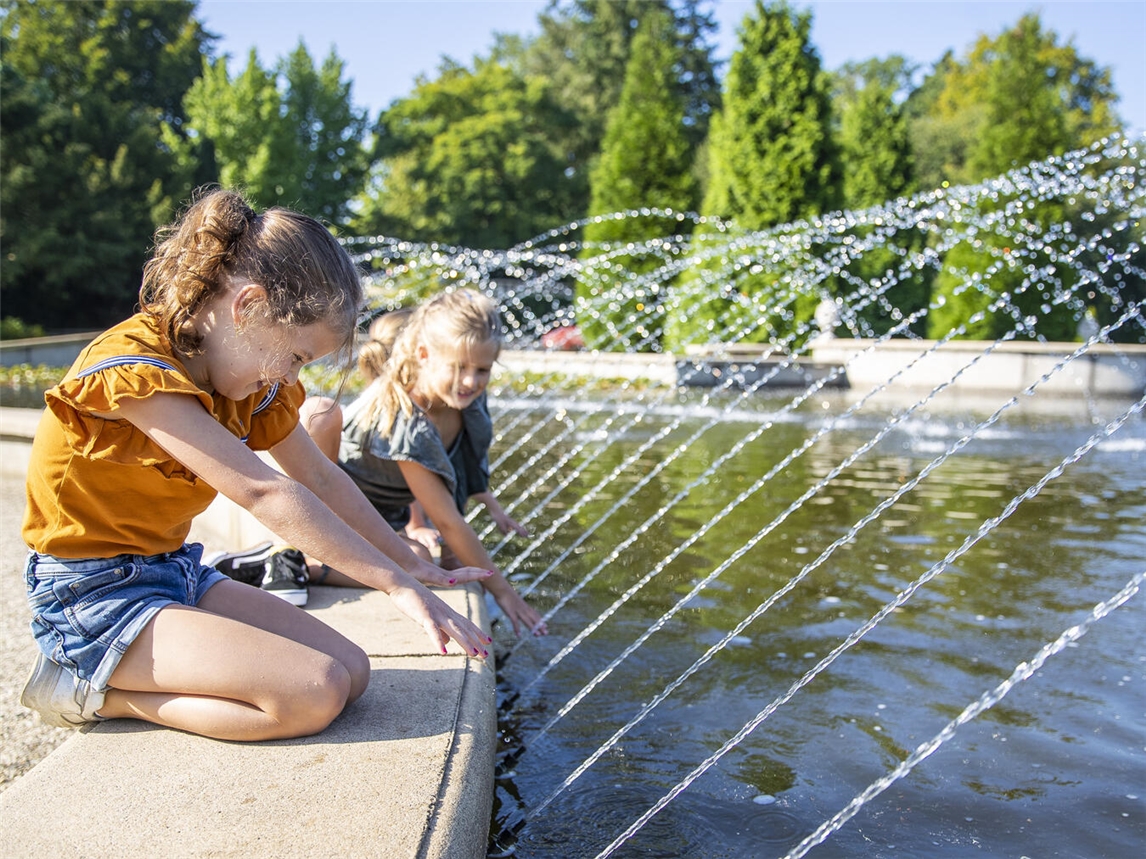 "Schlossgärten Arcen im Sommer: Familien genießen grüne Oase, Entspannung und Spaß bei sonnigem Wetter."