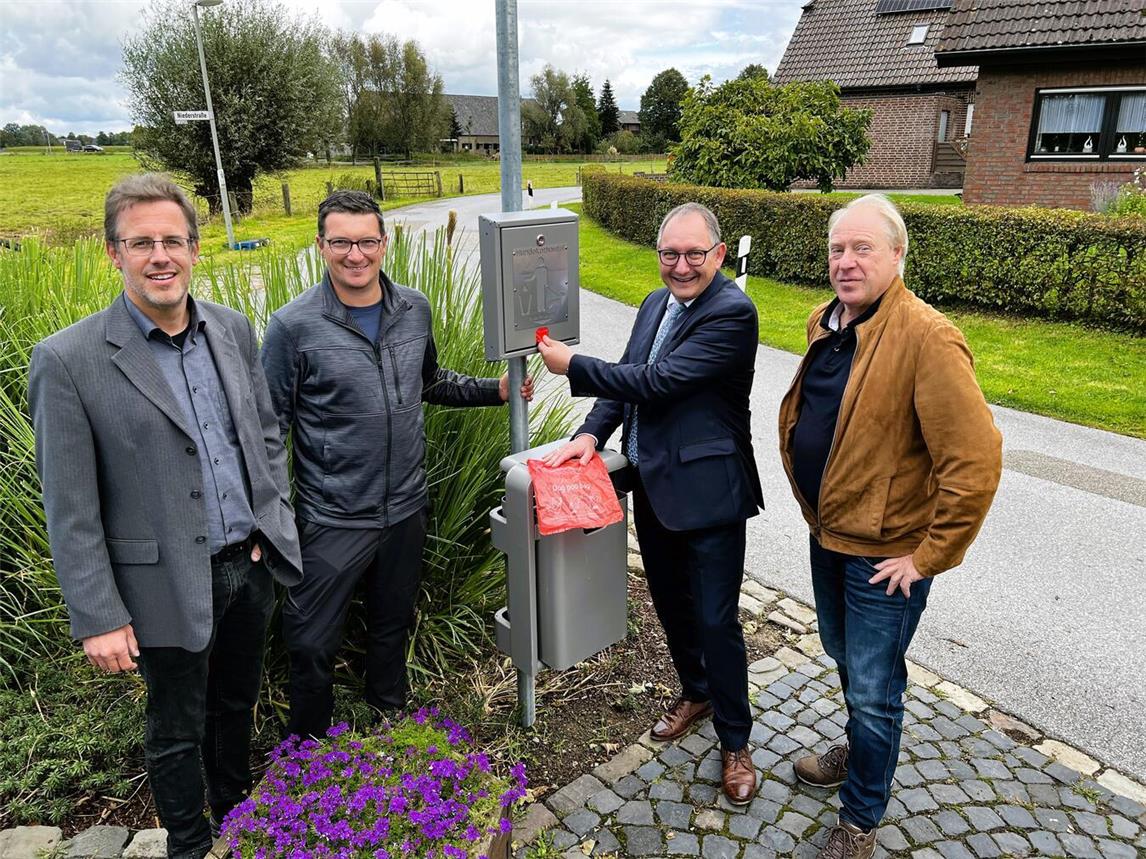Einer der insgesamt acht neuen Dog-Stations hängt in Bienen. Hier mit (v.l.) Frank Postulart, Ordnungsamt, Stefan Tekaat, Bauhof, Sebastian Hense, Bürgermeister, und Friedrich Freiherr von Wittenhorst, Ortsvorsteher Bienen. Foto: Stadt Rees