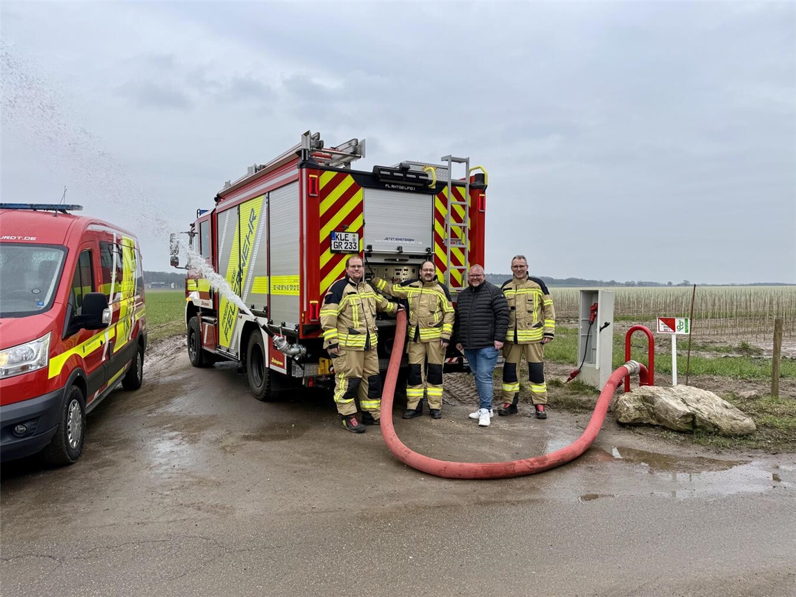 Einer der neuen Löschwasserbrunnen in Saelhuysen im Betrieb, davor eines der beiden neuen Löschfahrzeuge LF10: (v.l.n.r.) Marc Niessing (Löscheinheitsführer Rheurdt), Frank Diepers (Löscheinheitsführer Schaephuysen), Bürgermeister Dirk Ketelaers und Markus Gehrmann (Leiter der Feuerwehr).Foto: Galka
