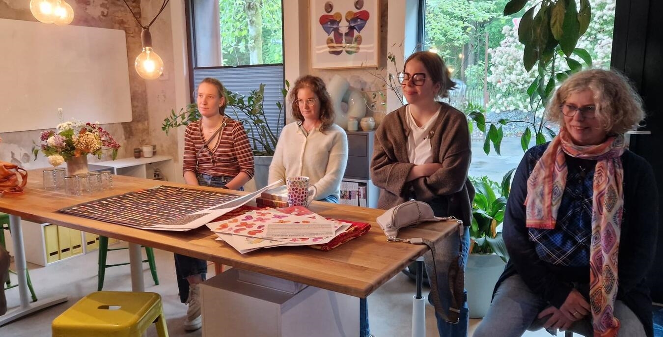 "Teilnehmerinnen beim Vortrag im modernen Design-Studio, kreatives Arbeitsumfeld"