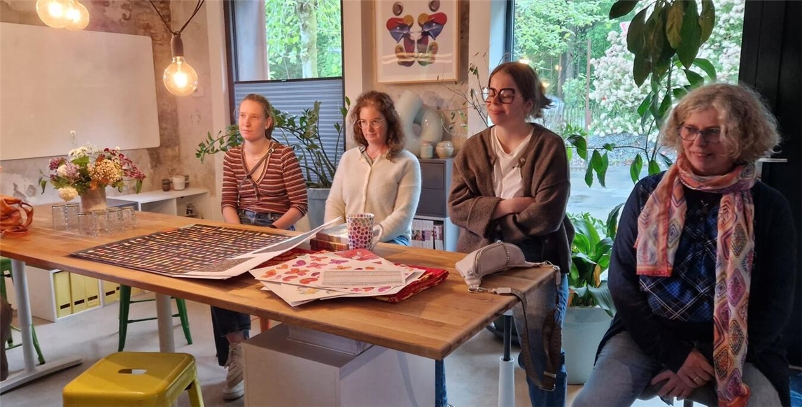 "Teilnehmerinnen beim Vortrag im modernen Design-Studio, kreatives Arbeitsumfeld"
