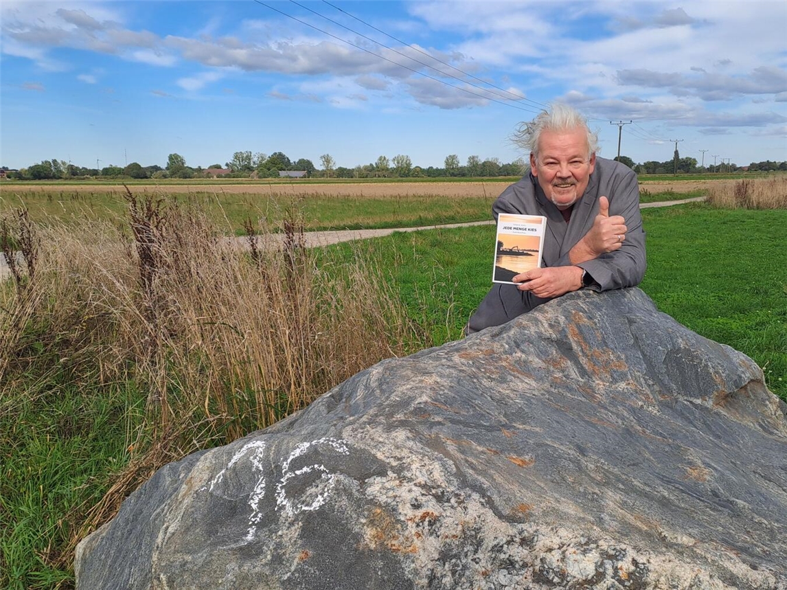 Erwin Kohl mit seinem Krimi vor dem Tatort in Alpen, an dem der Bauer in seiner Geschichte ermordet wurde. Foto: Bettina Kohl