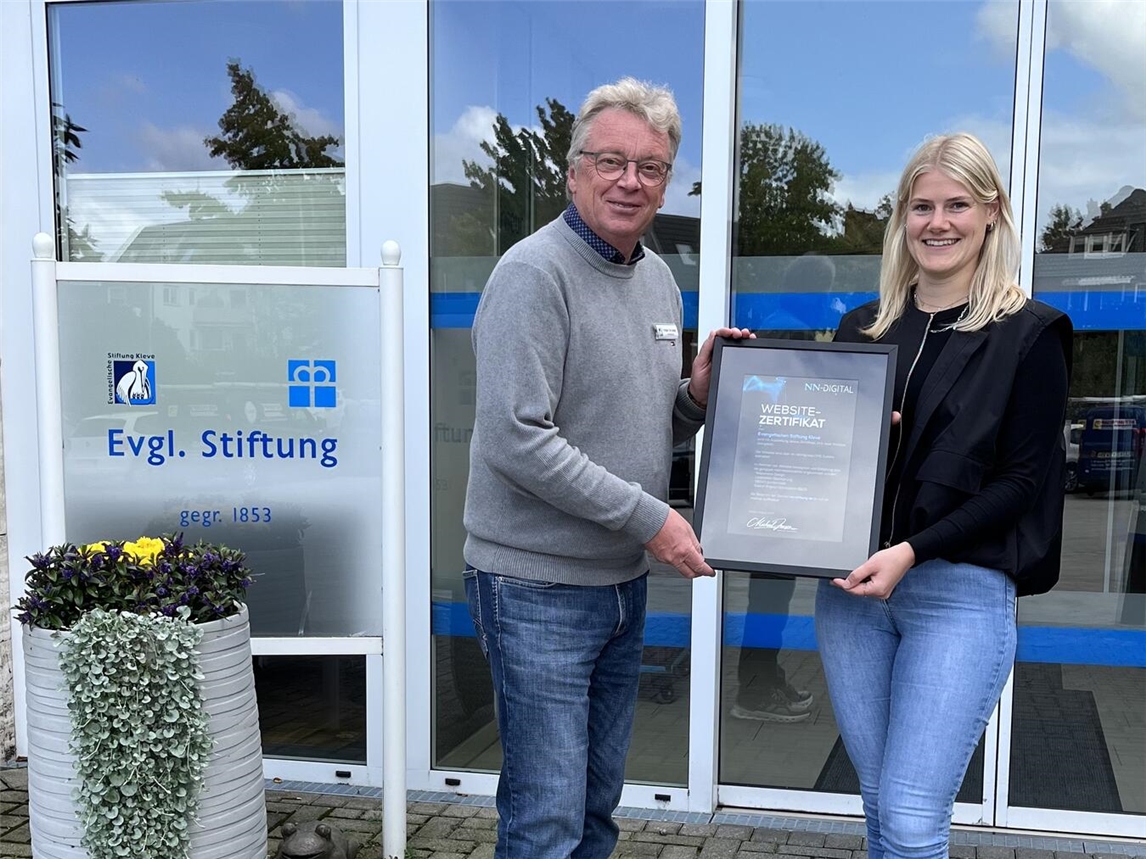 Eva van Betteray, Marketing Managerin bei NN-Digital, überreicht das Websitezertifikat an Holger de Lange, Heimleitung der Evangelischen Stiftung. Foto: NN
