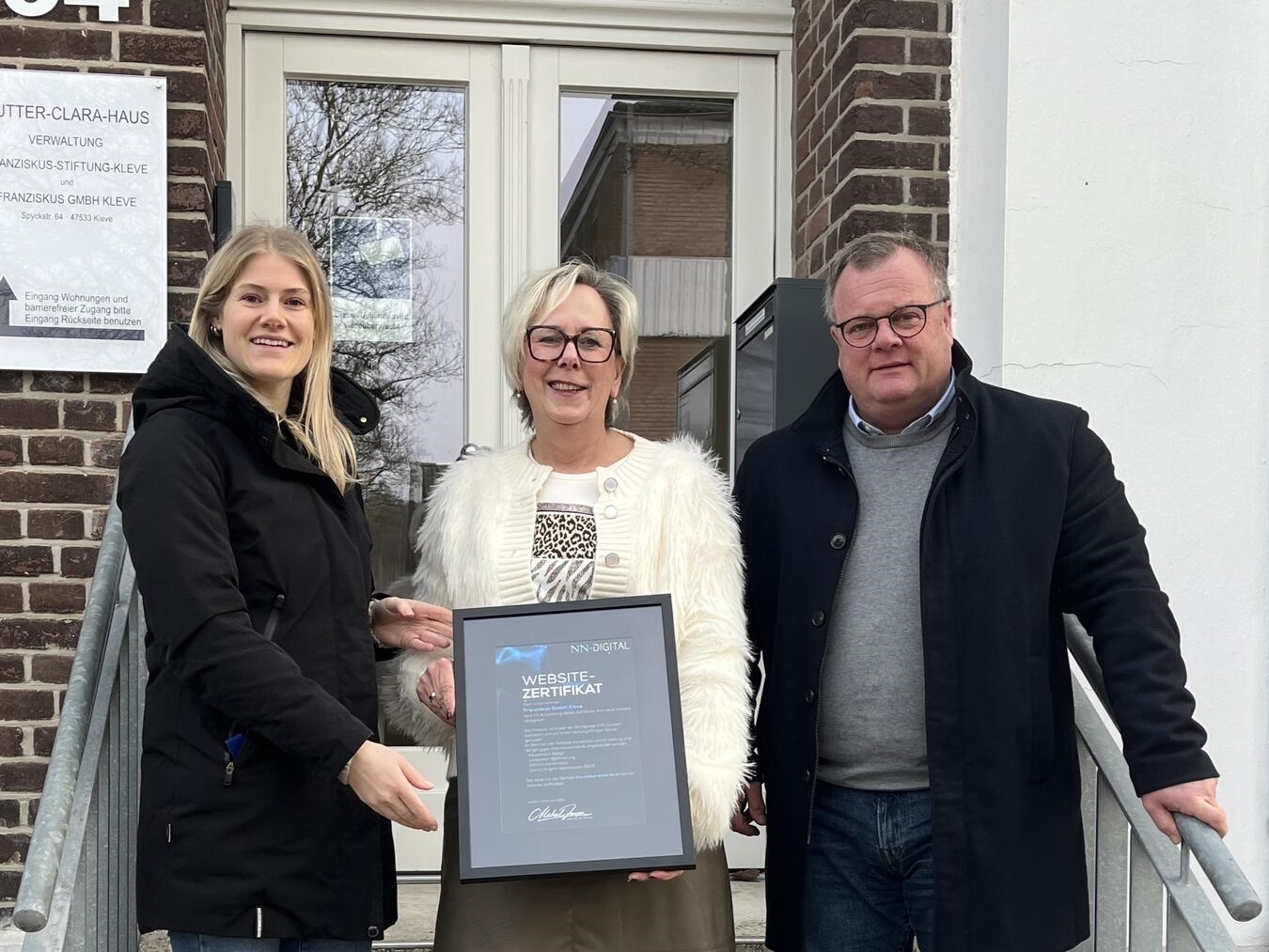 Eva van Betteray, Marketing Managerin bei NN-Digital, überreicht das Websitezertifikat an Andrea Waldmann und Alexander Noack von der Franziskus GmbH. Foto: privat