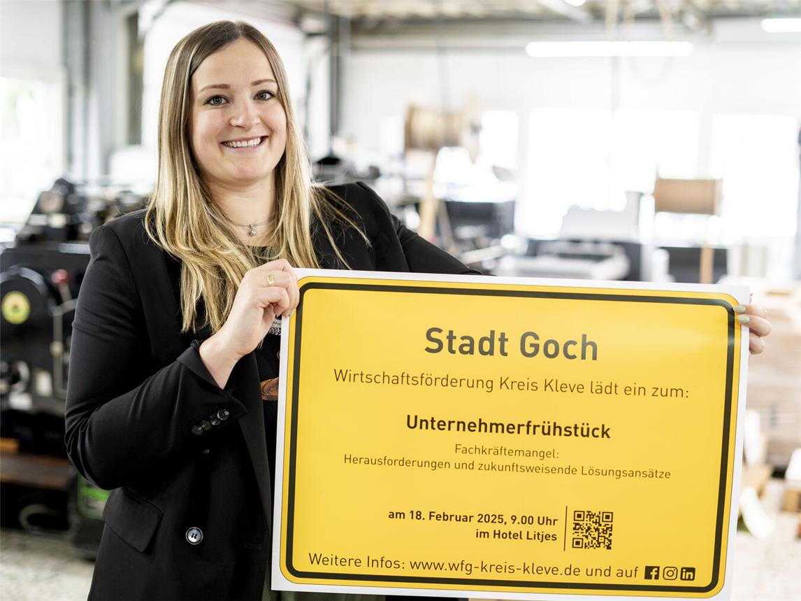 Fabienne van Lier von der Wirtschaftsförderung Kreis Kleve präsentiert das Ortsschild der Stadt Goch mit der Einladung zum Unternehmerfrühstück. Foto: Gerhard Seybert