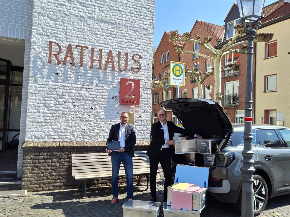 Fachbereichsleiter Torsten Schneider (links) und Sachgebietsleiter Kai Koenen (rechts) beim Verladen der Bauakten zur Digitalisierung. Foto: Stadt Xanten